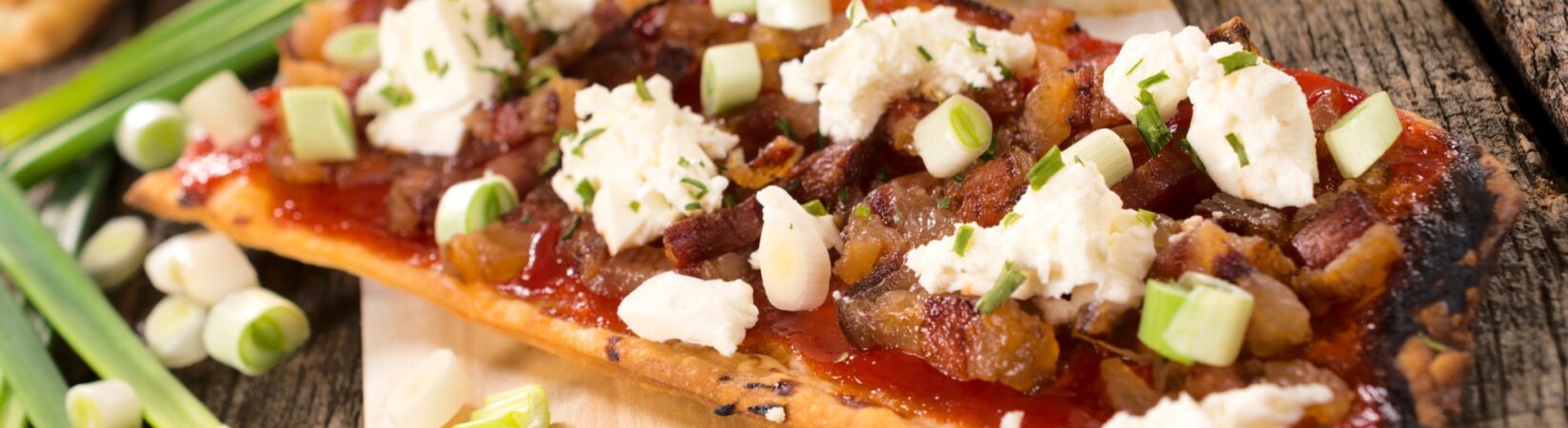 Pizza mit Schinkenwürfeln, Feta und Gurkensalat