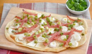Flammkuchen mit Schinken, Zwiebeln und Salat Flammkuchen mit Schinken, Zwiebeln und Salat