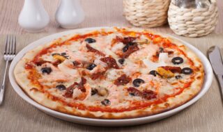 Dinkel-Pizza mit Meeresfrüchten und Tomatensalat