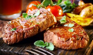 Gegrilltes Steak mit Kartoffeln und Tomaten Gegrilltes Steak mit Kartoffeln und Tomaten