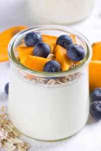 Joghurt mit Blaubeeren, Kaki und Müsli