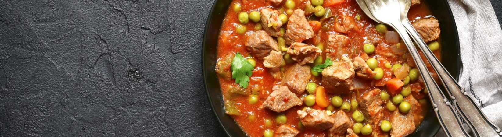 Kalbseintopf mit Erbsen, Paprika und Möhren in Tomatensauce