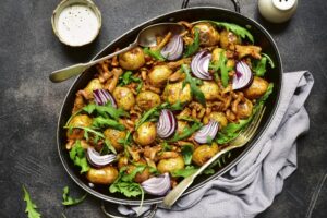 Kartoffelpfanne mit Pfifferlingen, roten Zwiebeln und Rucola