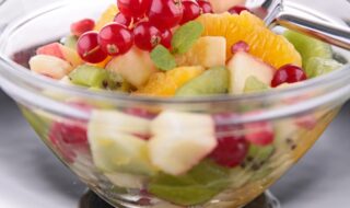 Obstsalat mit Orange, Apfel, Kiwi und Johannisbeeren