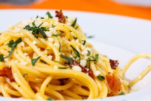 Pasta mit getrockneten Tomaten, Feta und grünem Salat