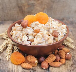 Porridge mit Apfel, getrockneten Aprikosen und Nüssen