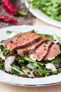 Rinderstreifen auf Rucola-Linsensalat mit Senfcreme