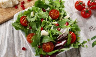 Salat mit Tomaten, Parmesan, Rucola und Granatapfel