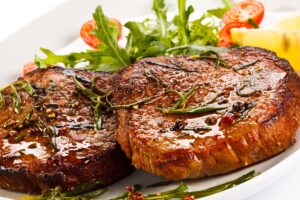 Schweinesteak mit Rucolasalat und Tomaten