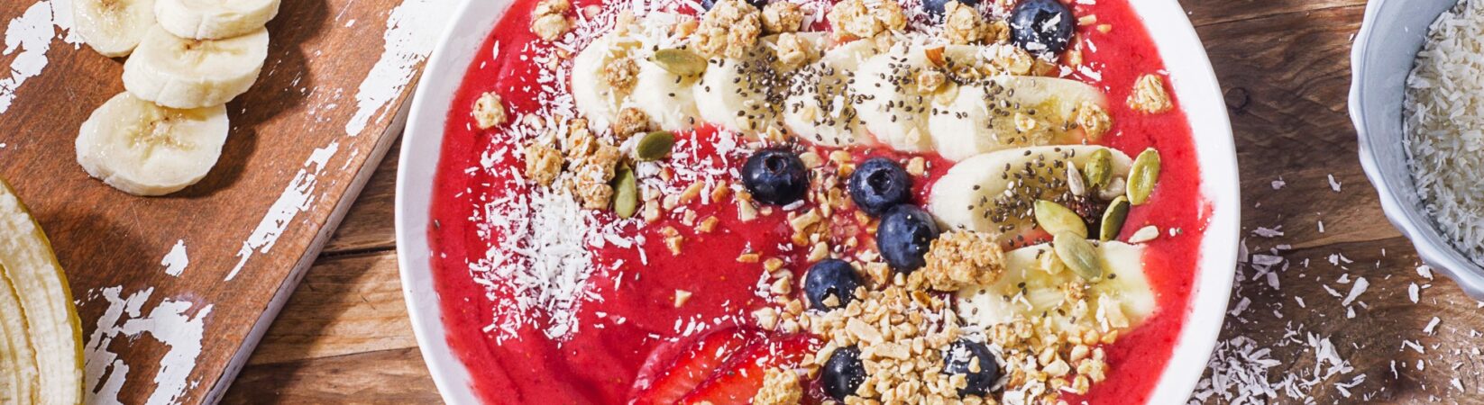 Smoothie-Bowl mit Erdbeeren, Banane, Kokos und Haselnüssen