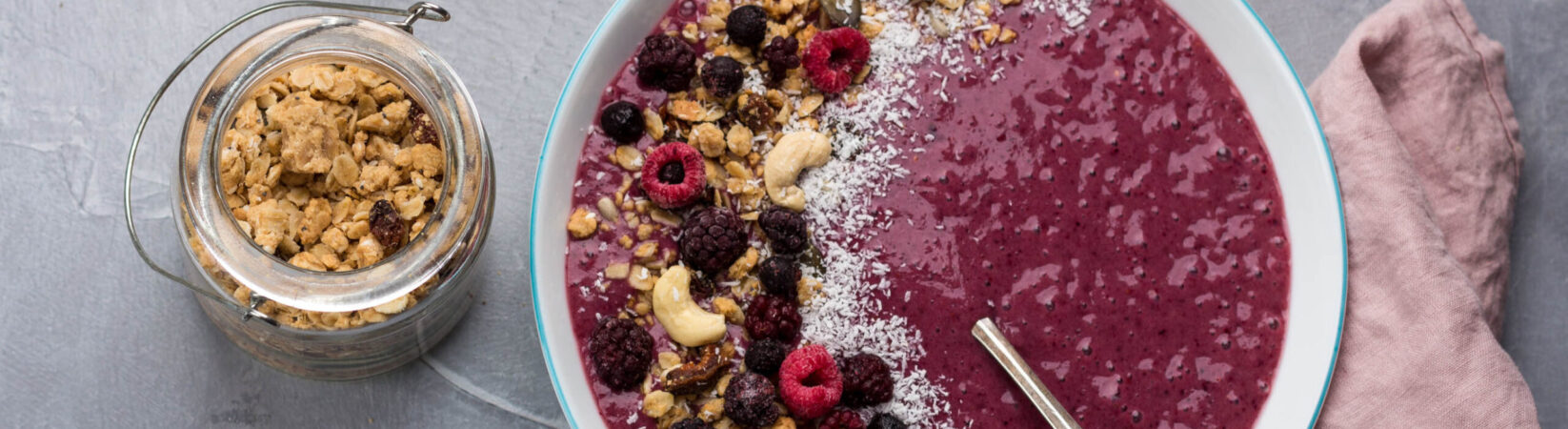 Smoothie Bowl mit Himbeeren, Granola und Kokosflocken