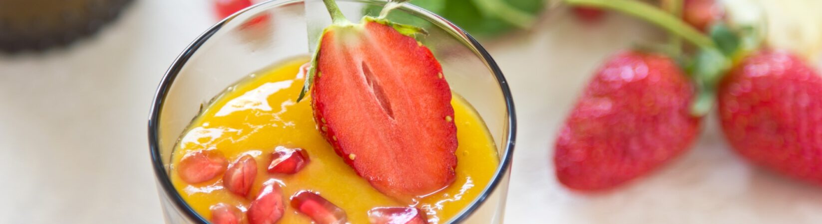 Smoothie mit Mango, Erdbeeren und Granatapfelkernen