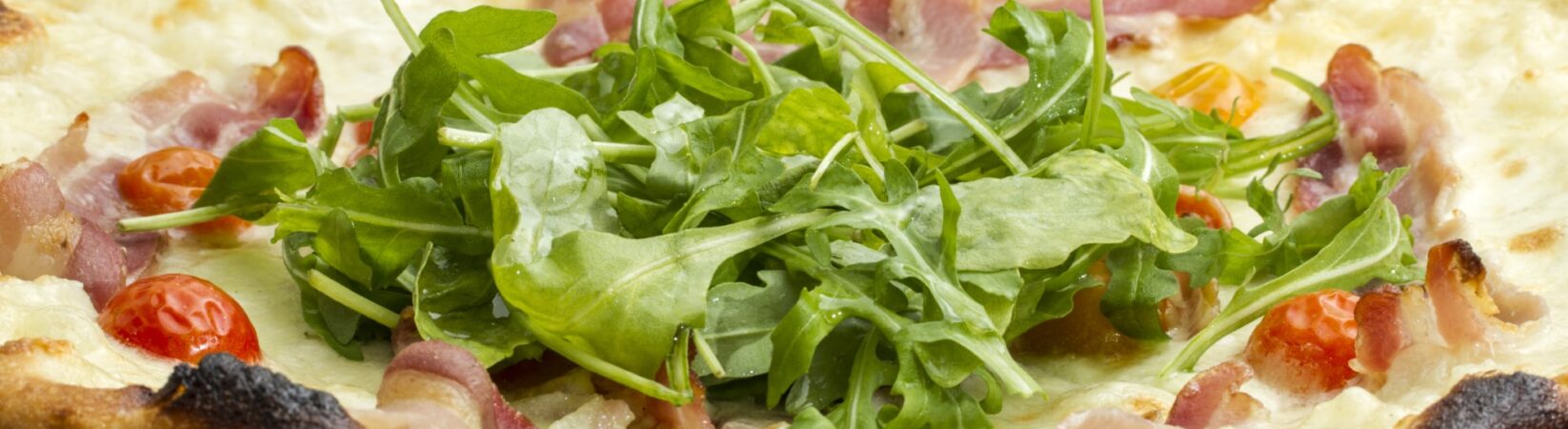 Pizza mit Parmaschinken, Rucola und Salat