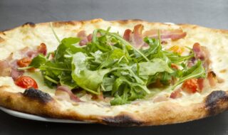 Pizza mit Parmaschinken, Rucola und Salat