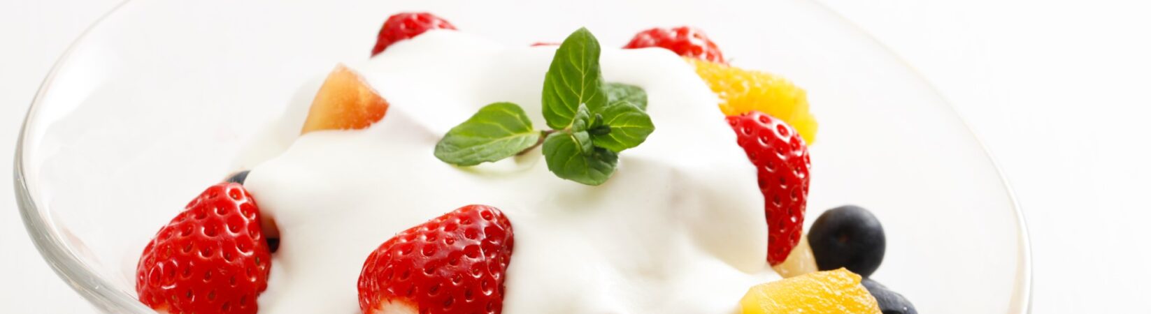 Obstsalat mit Erdbeeren, Orange, Blaubeeren und Quark