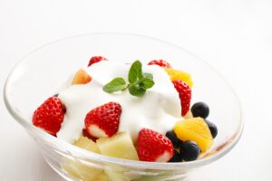 Obstsalat mit Erdbeeren, Orange, Blaubeeren und Quark